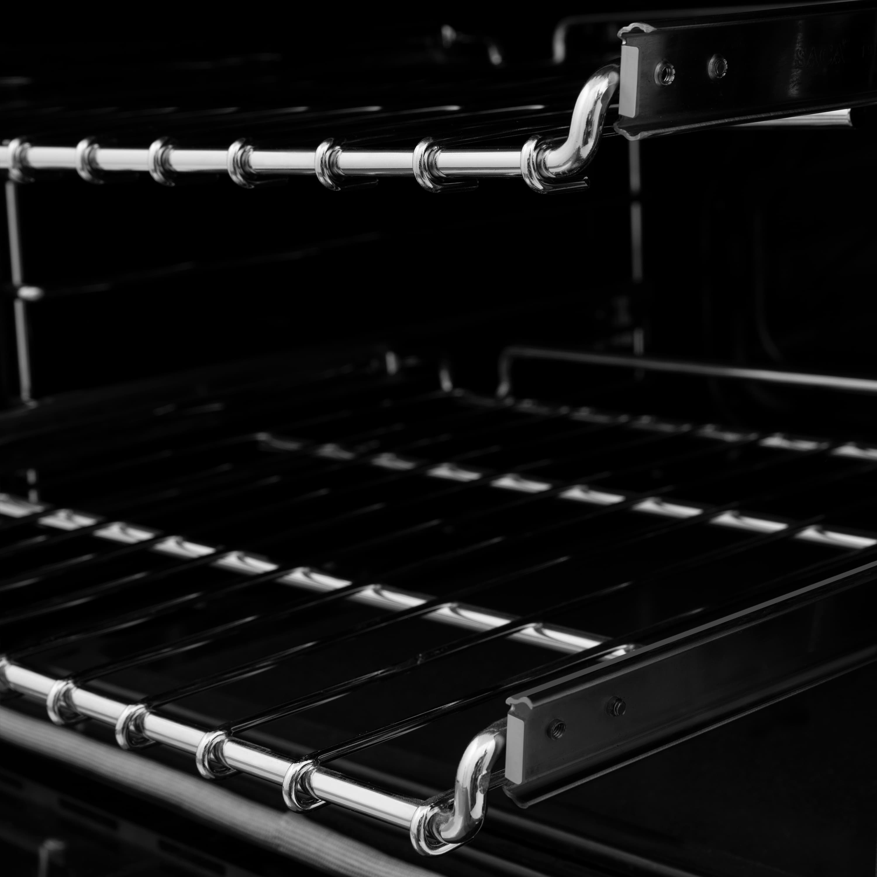 Chrome oven racks with burner components inside a black gas oven