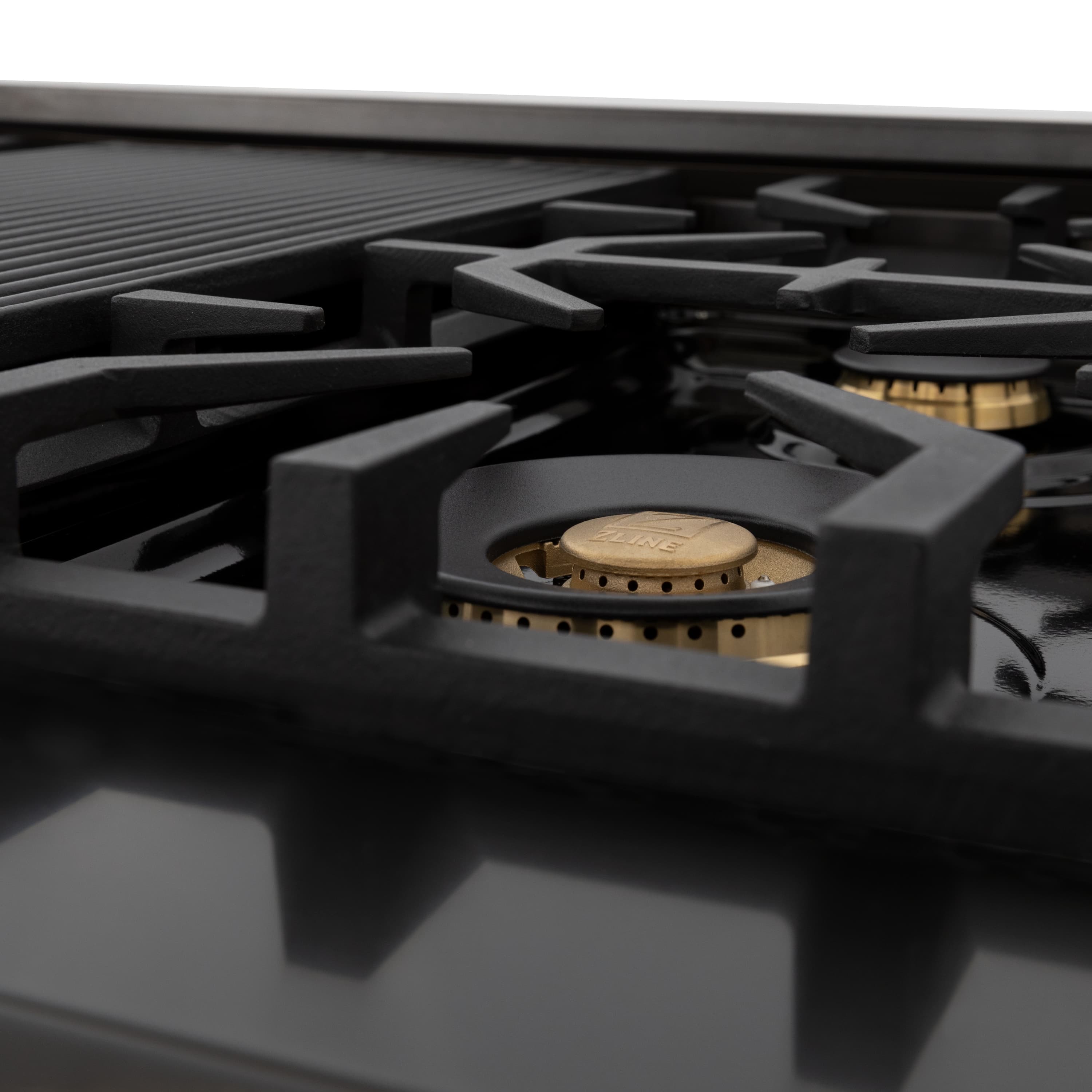 Close-up of black gas burner with brass-colored flame cap
