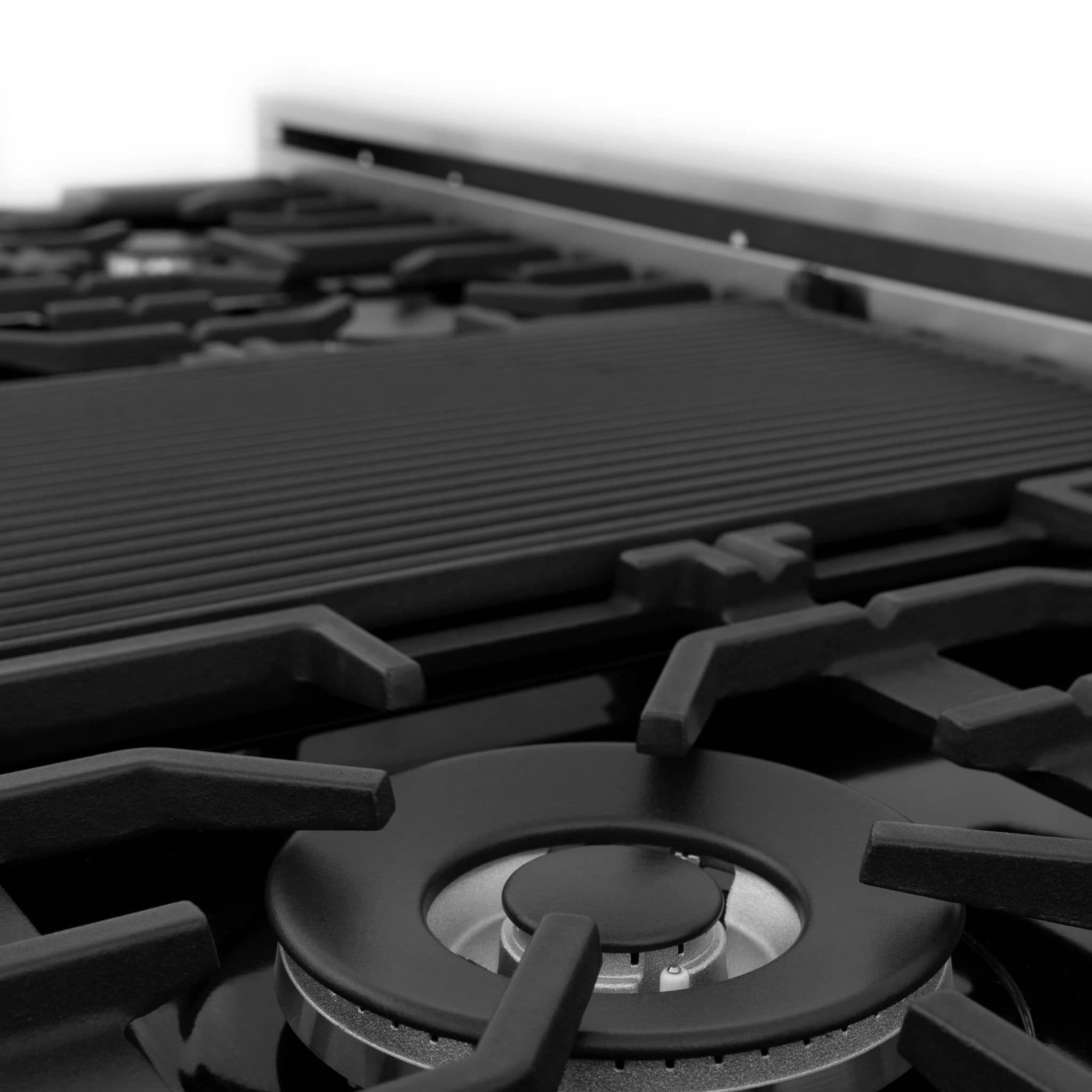 Close-up of black gas burner cap with metal grate and round control area