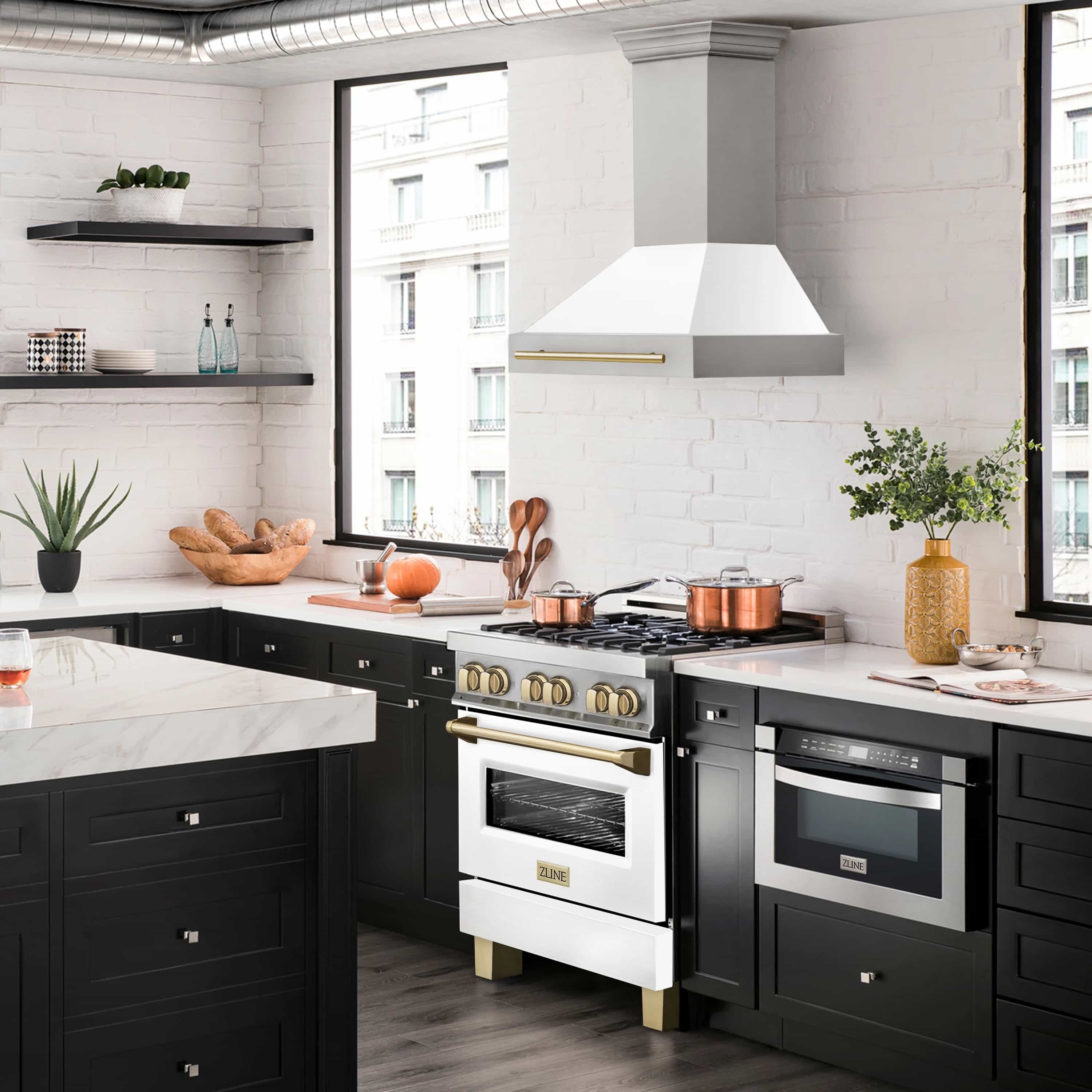 Wall mount range hood over cooktop, white matte chimney with gold trim in a kitchen setting.
