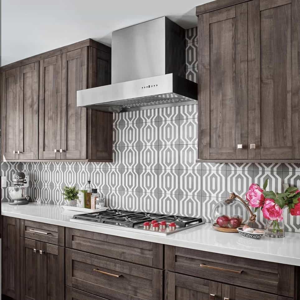 Stainless steel range hood over a cooktop with chimney duct and baffle filter area