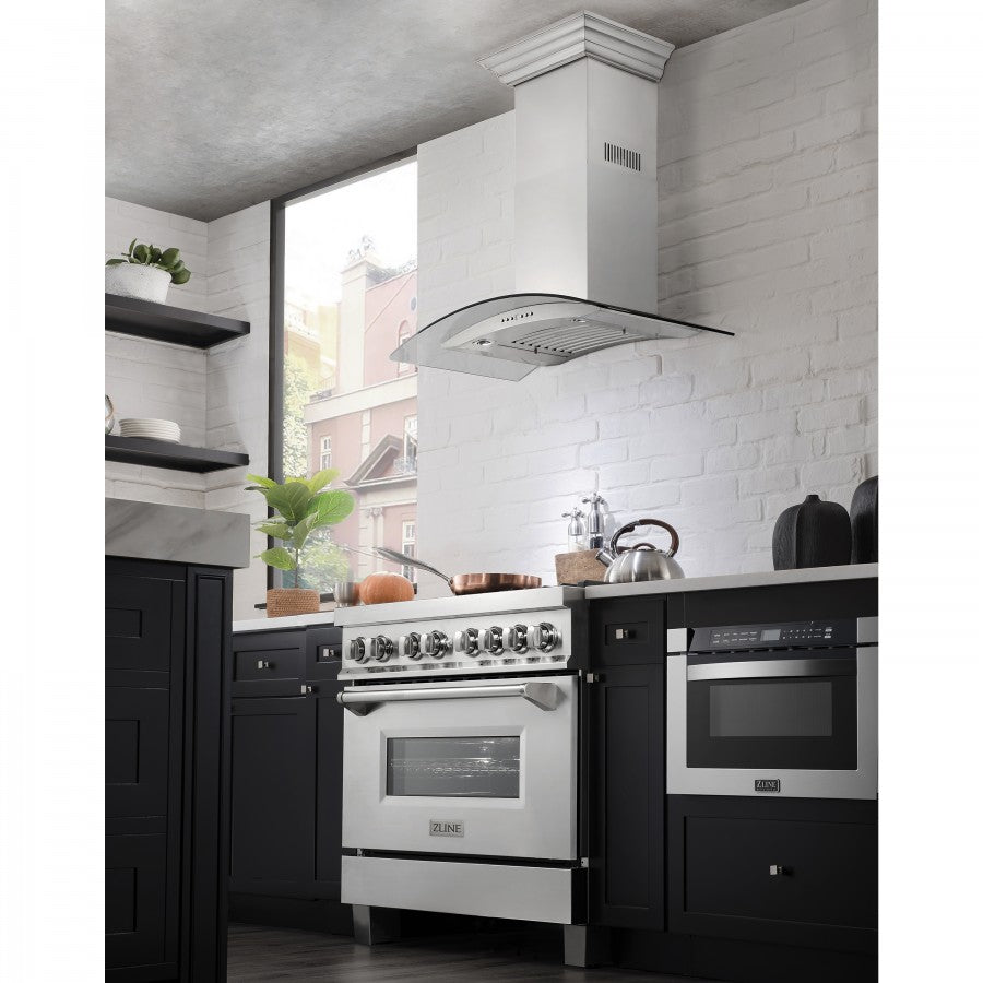 Stainless steel wall mount range hood with curved glass canopy above stovetop.