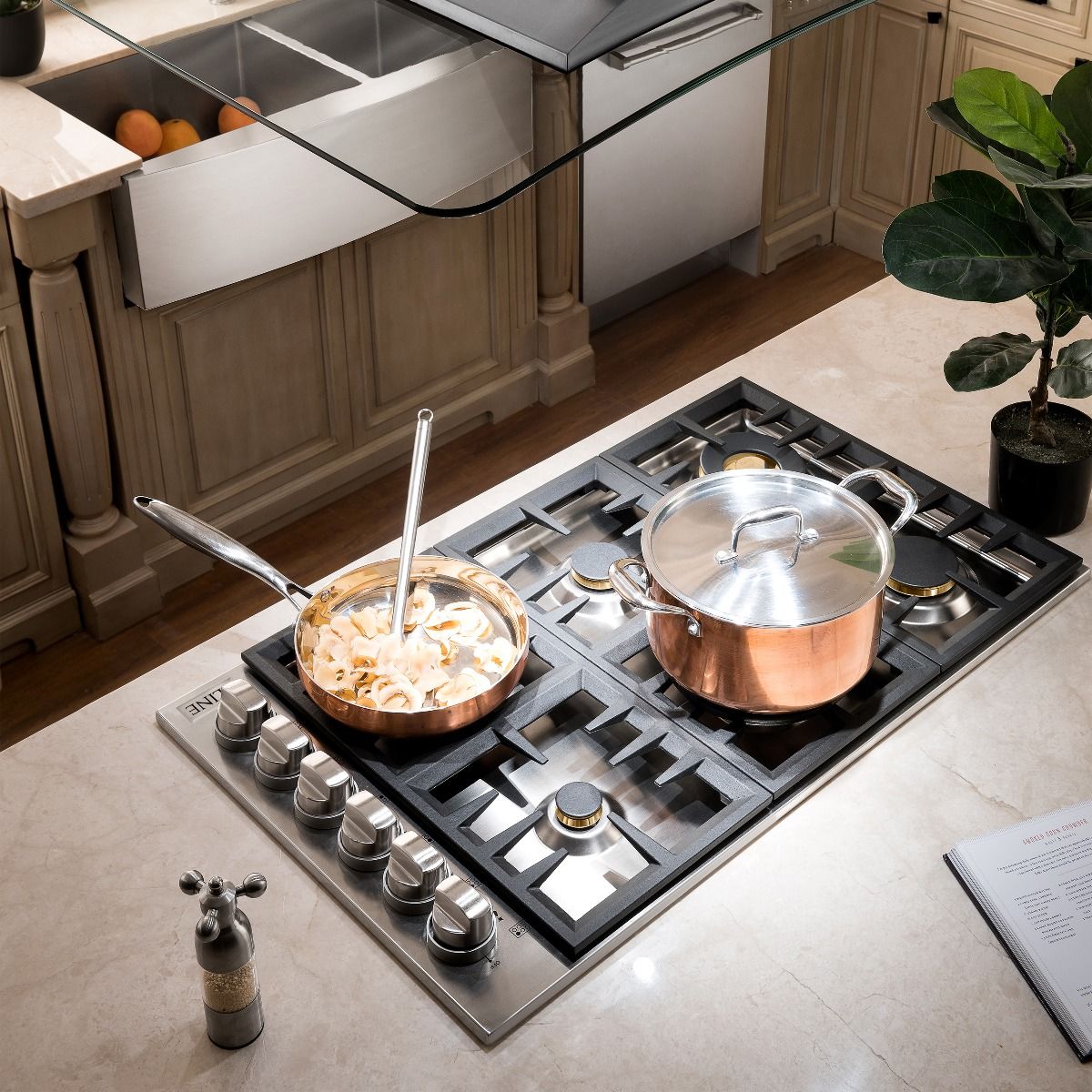 Black gas cooktop with four burners, cast-iron grates, and cookware on top