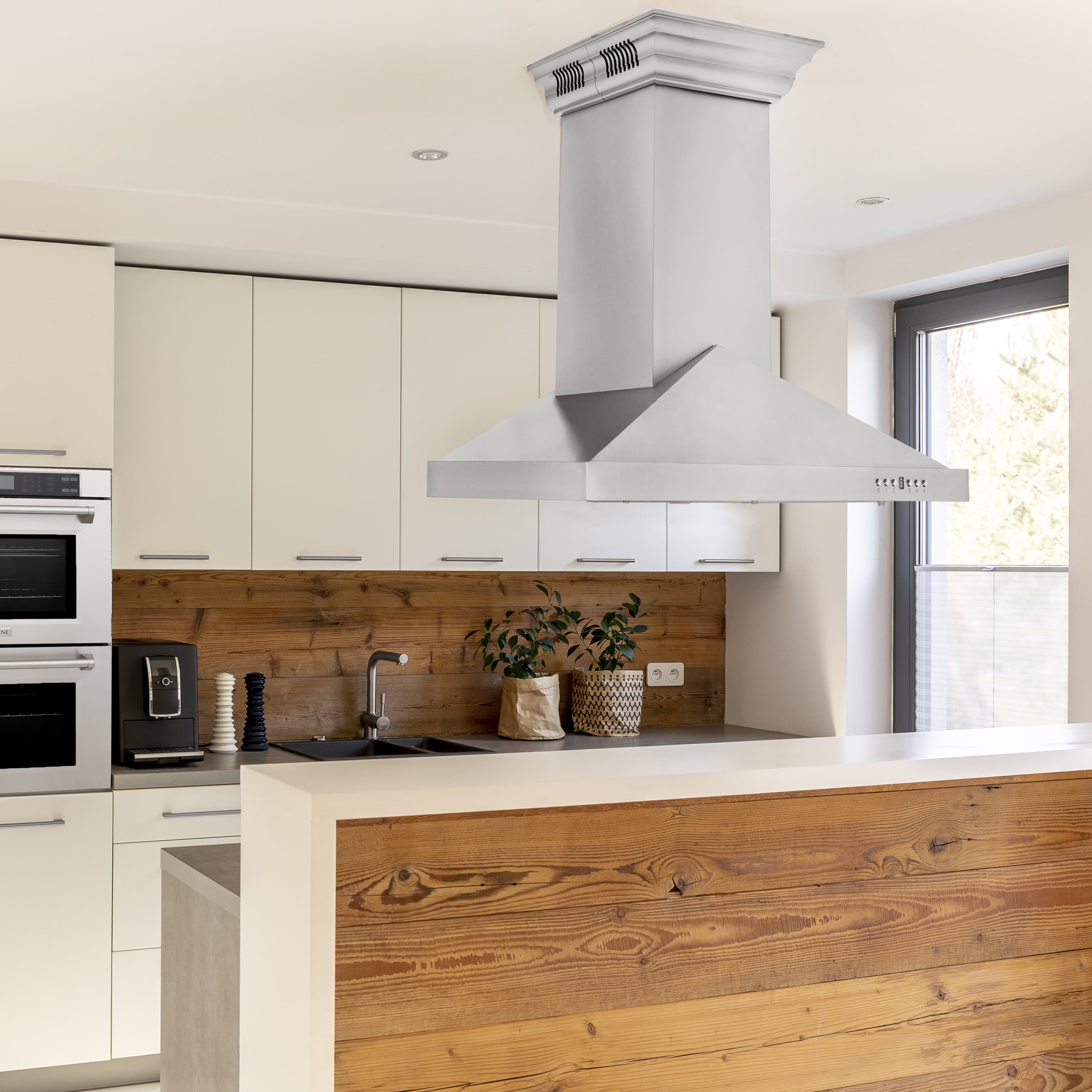 Stainless steel island-mounted ducted range hood with chimney-style body and wide canopy