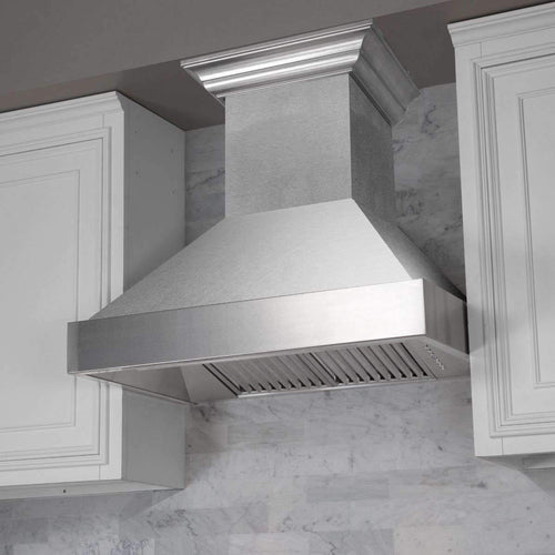 Stainless convertible vent range hood installed over a cooktop with chimney duct