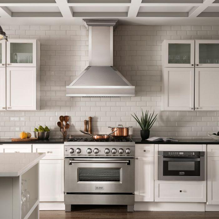 Wall-mount range hood above the cooktop with satin stainless steel and mirror accents