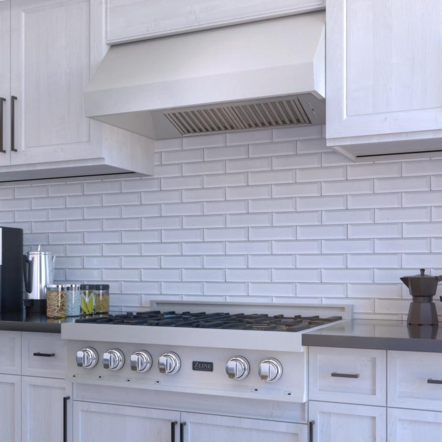 Under-cabinet stainless range hood above a gas cooktop with front control knobs