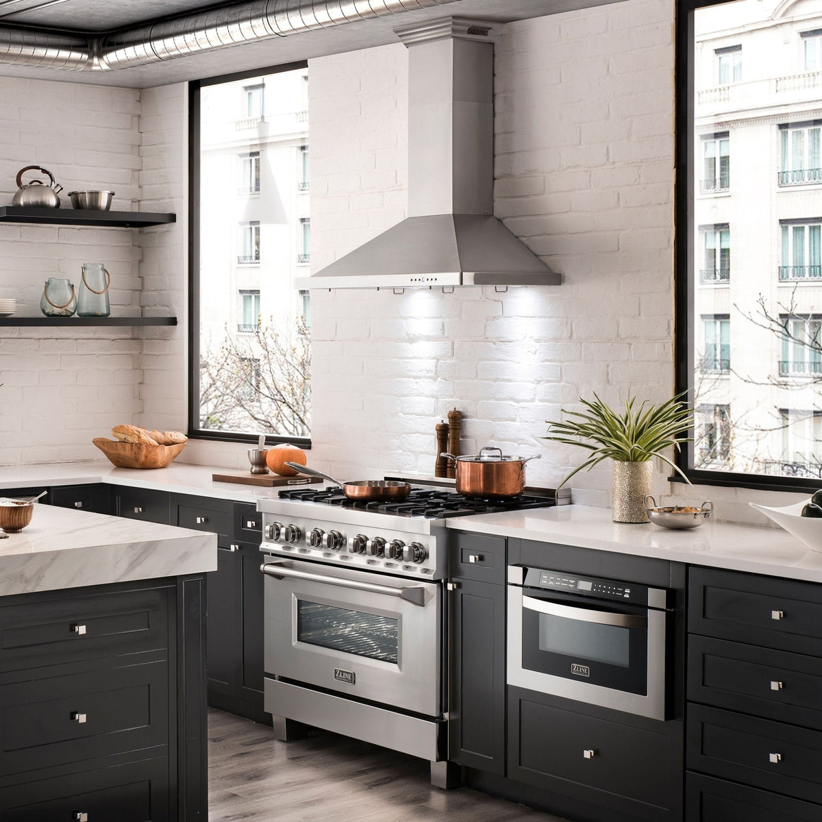 Stainless steel wall mount range hood over cooktop in a kitchen setting