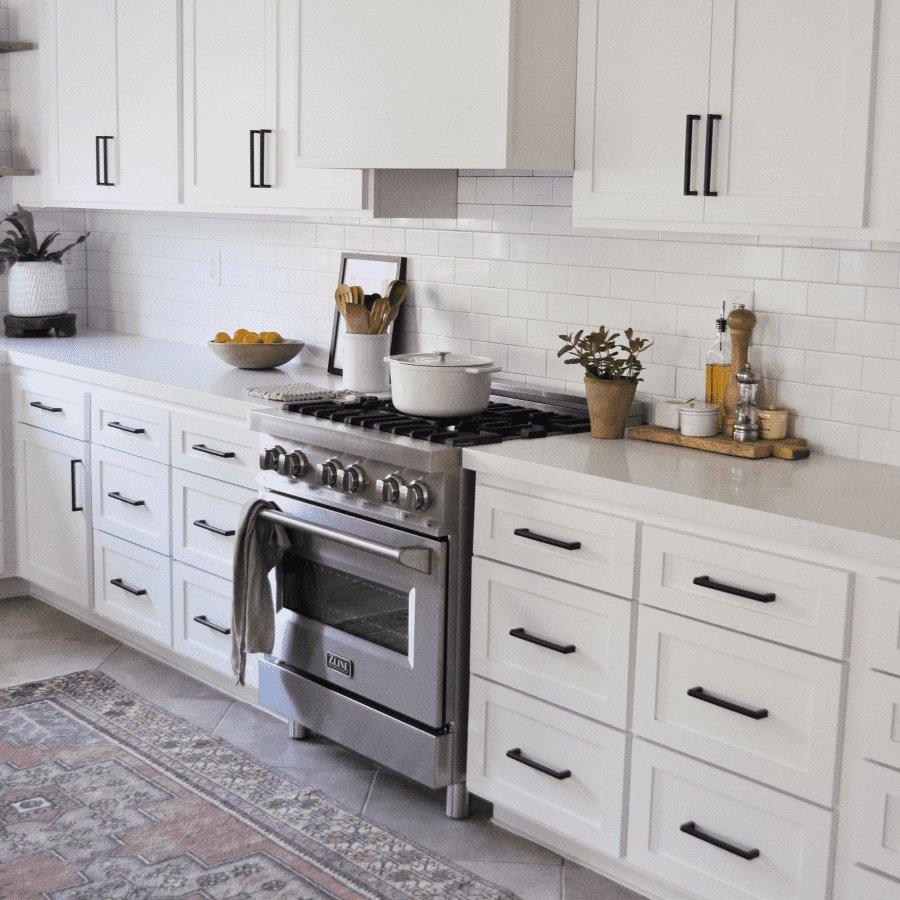 Stainless dual-fuel range with 4 gas burners and closed electric oven door in kitchen