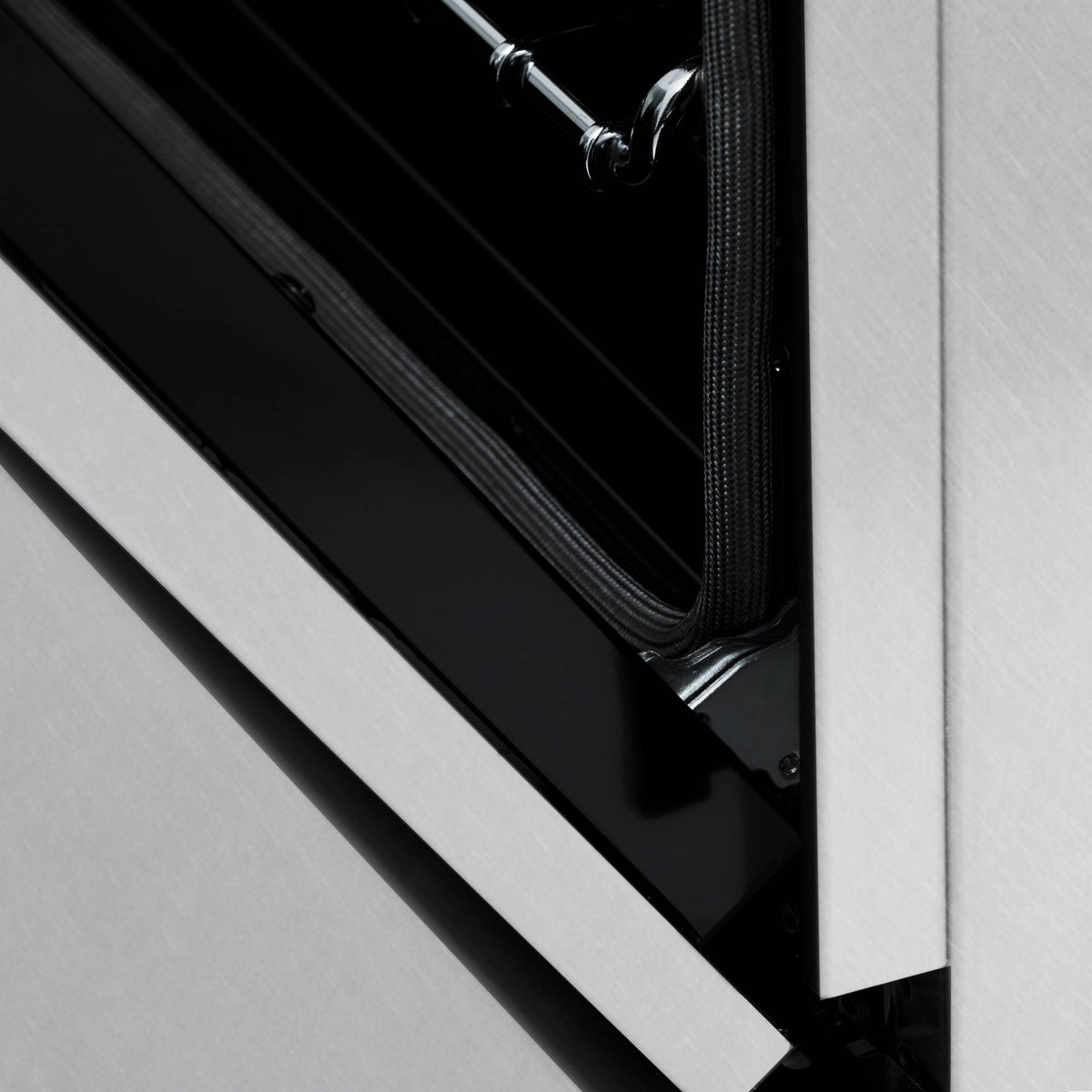 Dual fuel range oven door hinge area with black gasket and stainless frame