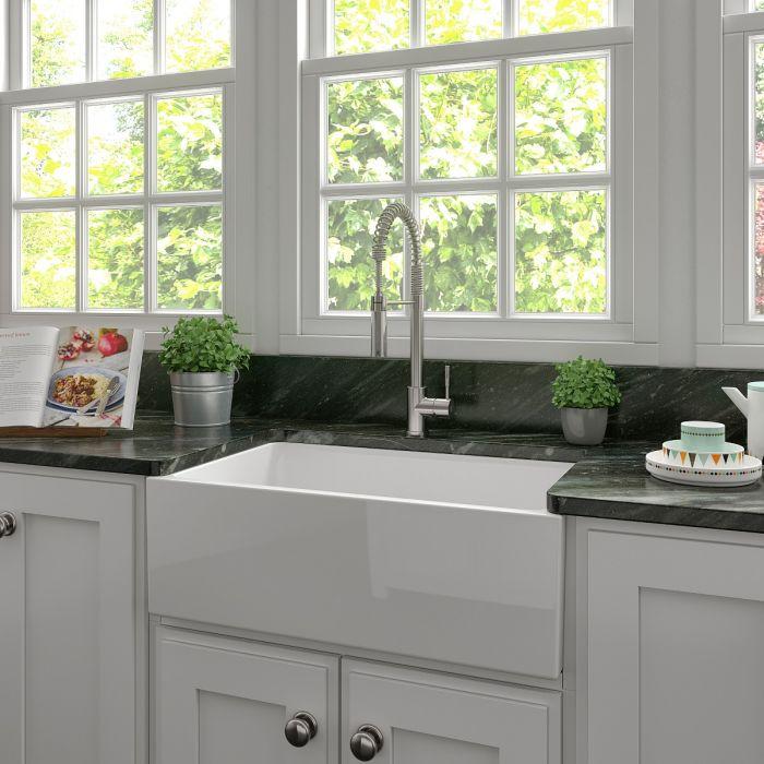 White farmhouse apron-front fireclay kitchen sink with chrome faucet, single bowl