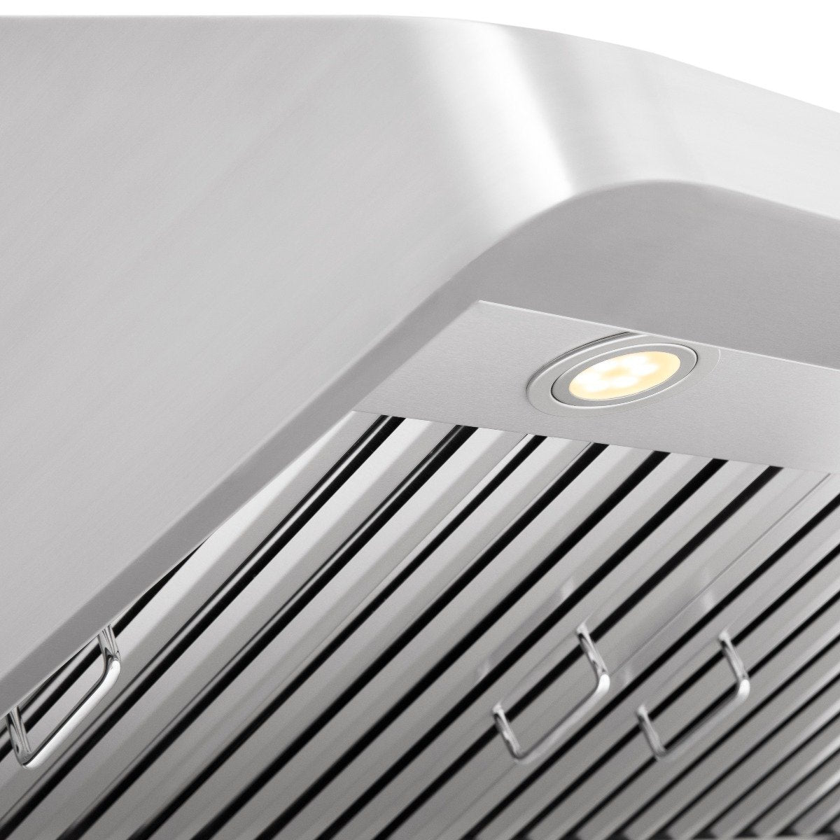 Stainless steel range hood underside with glowing light and baffle grates