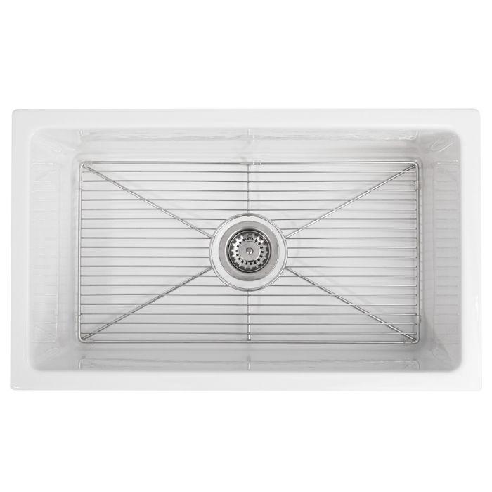 White sink basin with chrome drain fitting and bottom grid