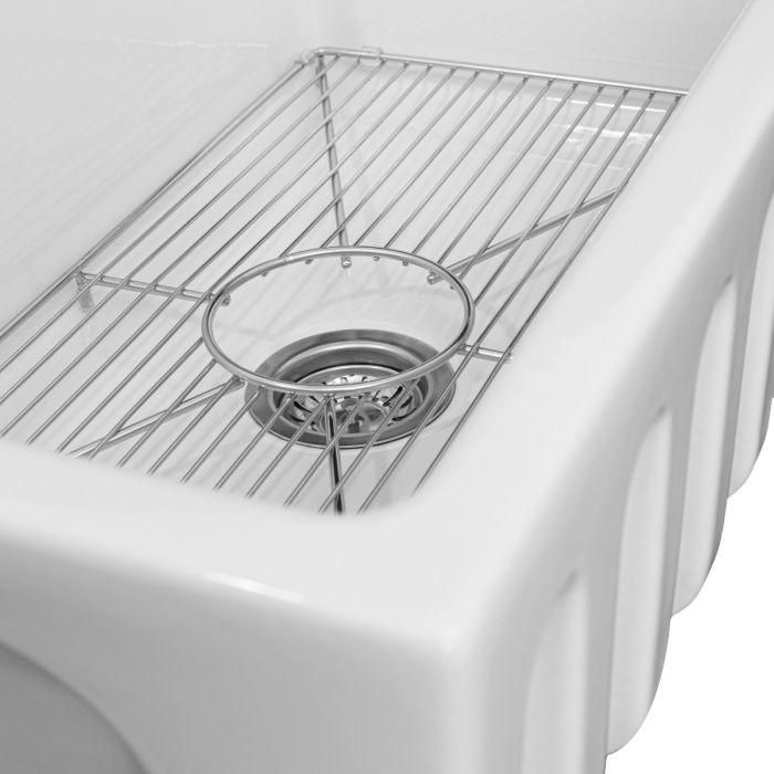 White single-bowl sink with chrome bottom grid and round drain strainer