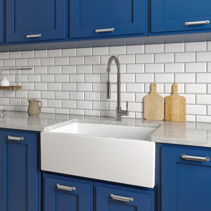 White farmhouse apron-front single-bowl sink with chrome faucet and basin front