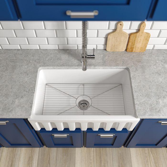 White apron-front single-bowl fireclay sink with grooved apron and faucet