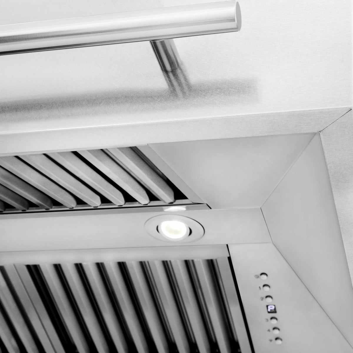 Stainless steel range hood underside with vent louvers, circular light, and control panel