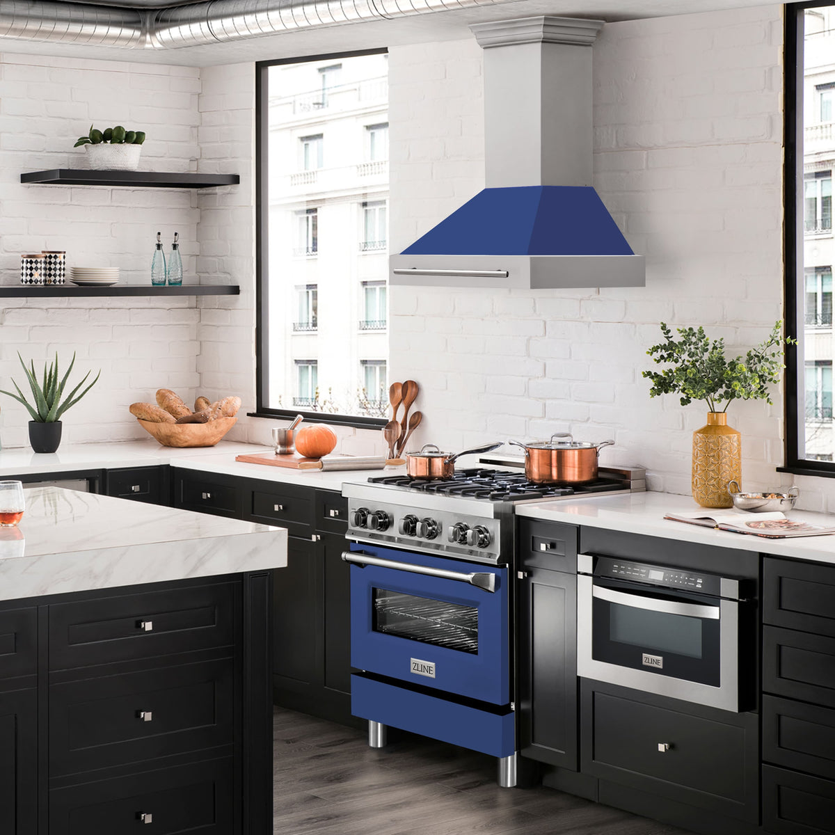 Blue matte wall mount range hood centered over a black kitchen range with stainless knobs and ovens