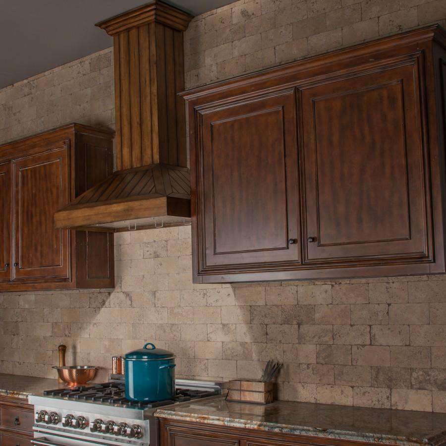 Rustic light wood wall range hood installed above cooktop in a kitchen