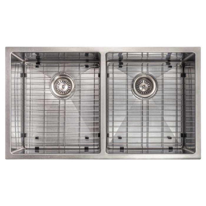 Stainless steel double-bowl undermount kitchen sink with round strainers and grid racks visible