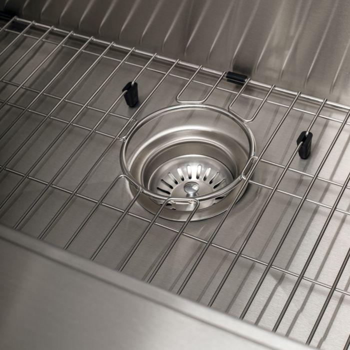 Bottom grid inside stainless sink with basket strainer centered over drain