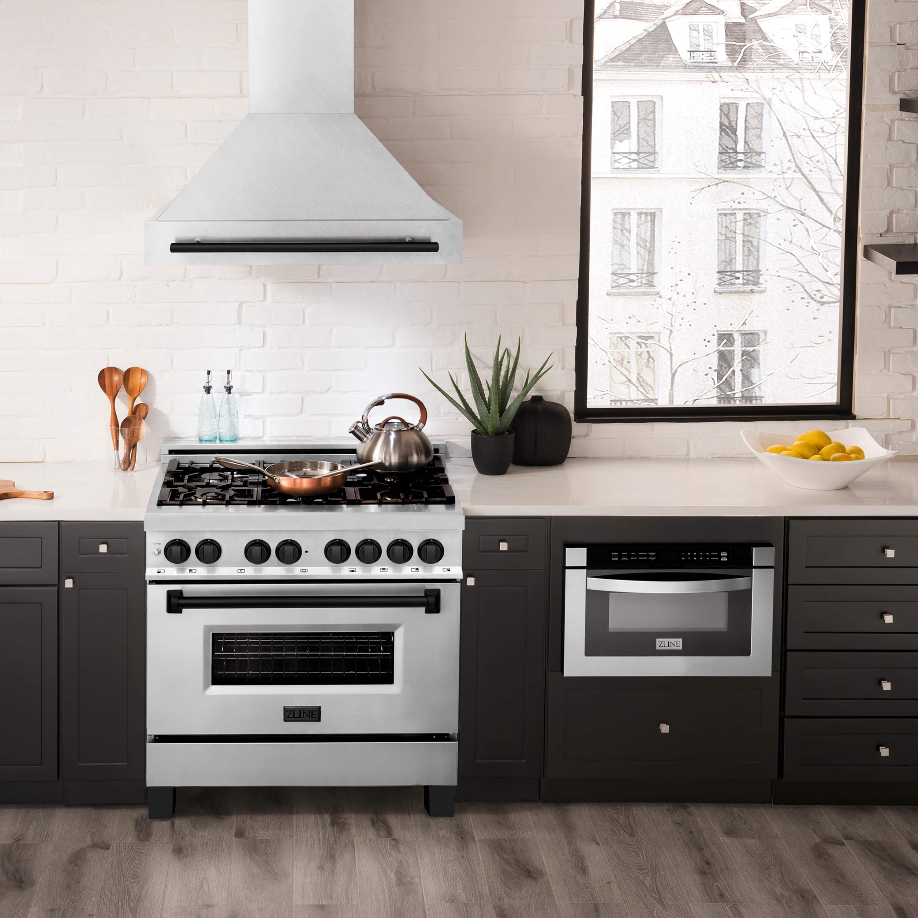 Satin stainless wall mount range hood with matte black handle above cooktop