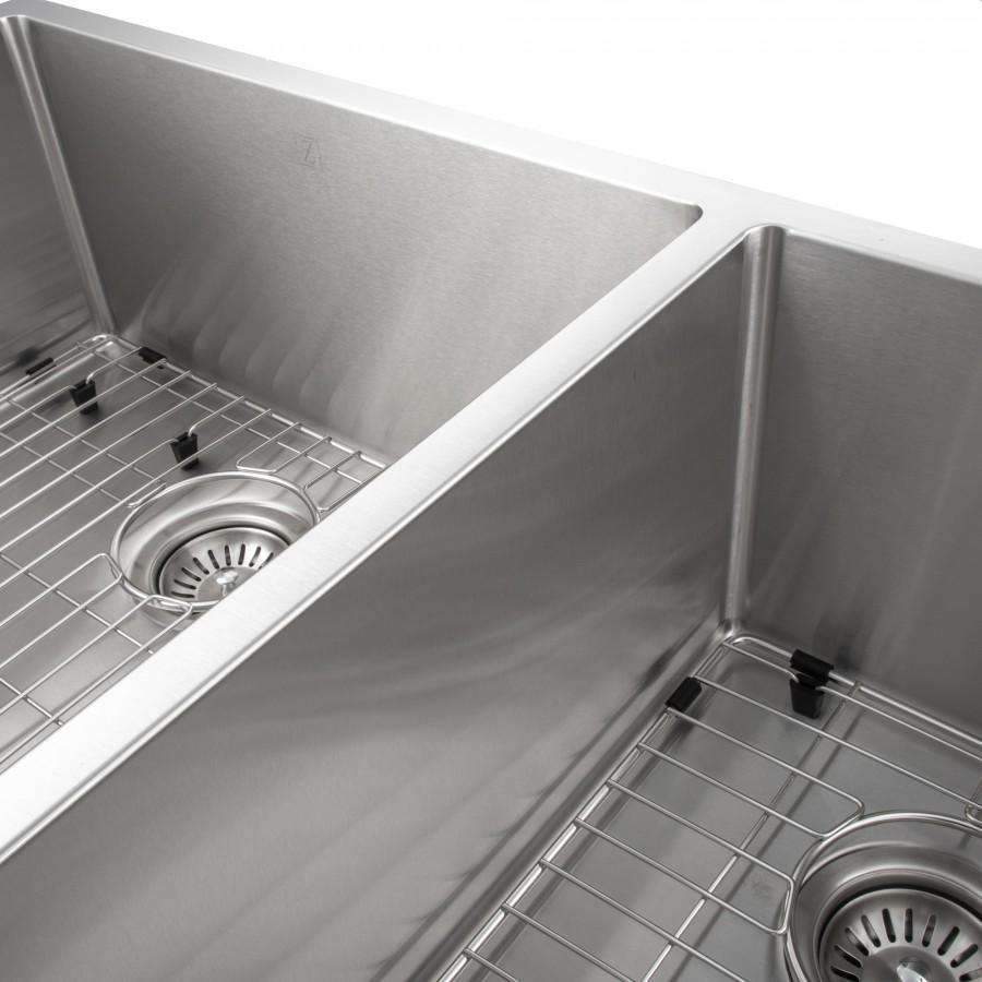 Stainless steel sink corner close-up with grid rack and round drain strainer