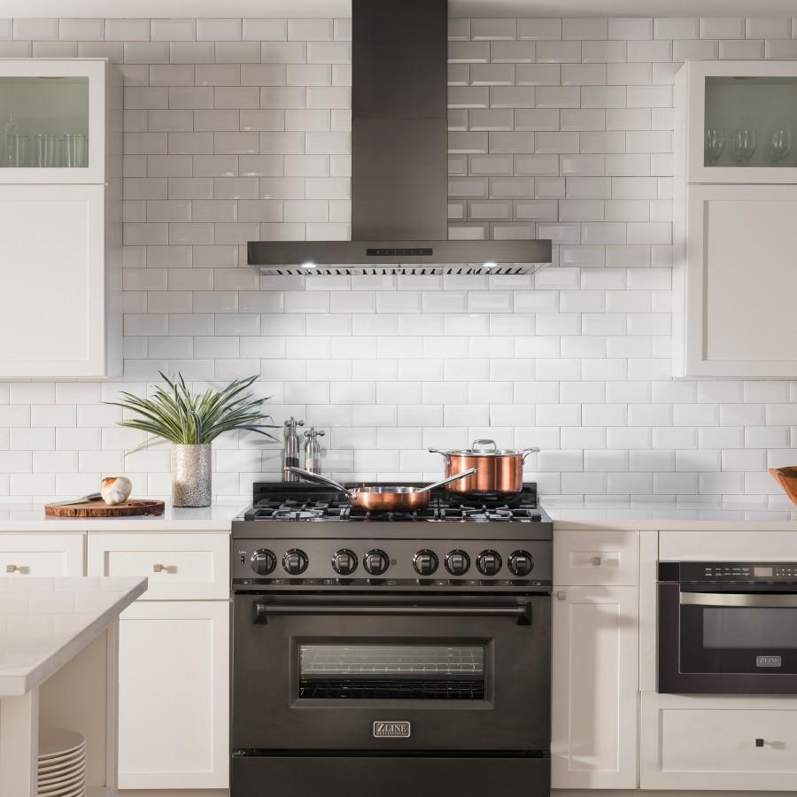 Black stainless convertible vent wall mount range hood above a cooktop