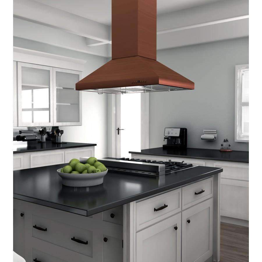Copper island range hood centered over black countertop cooktop, chimney visible