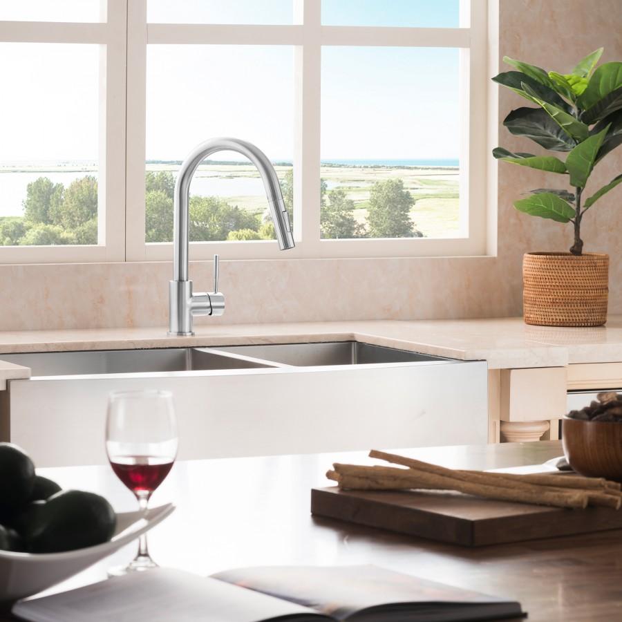 Apron-mounted double-basin stainless steel sink with faucet and stainless rim.