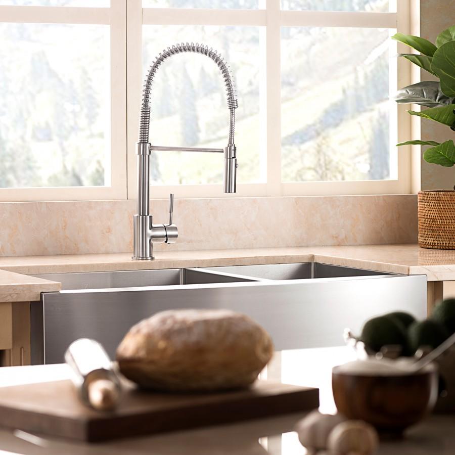 Kitchen sink with twin basins and high-arc faucet mounted on an apron-style stainless front.