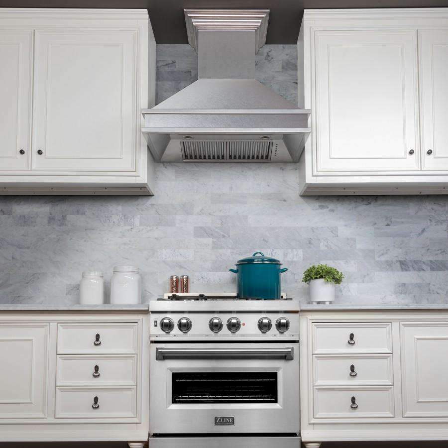 Satin stainless steel wall chimney range hood centered above a gas range