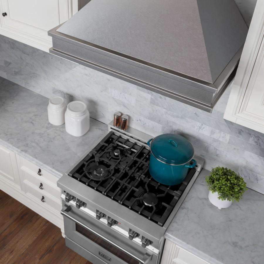 Satin stainless steel wall mount range hood at stovetop level with cookware