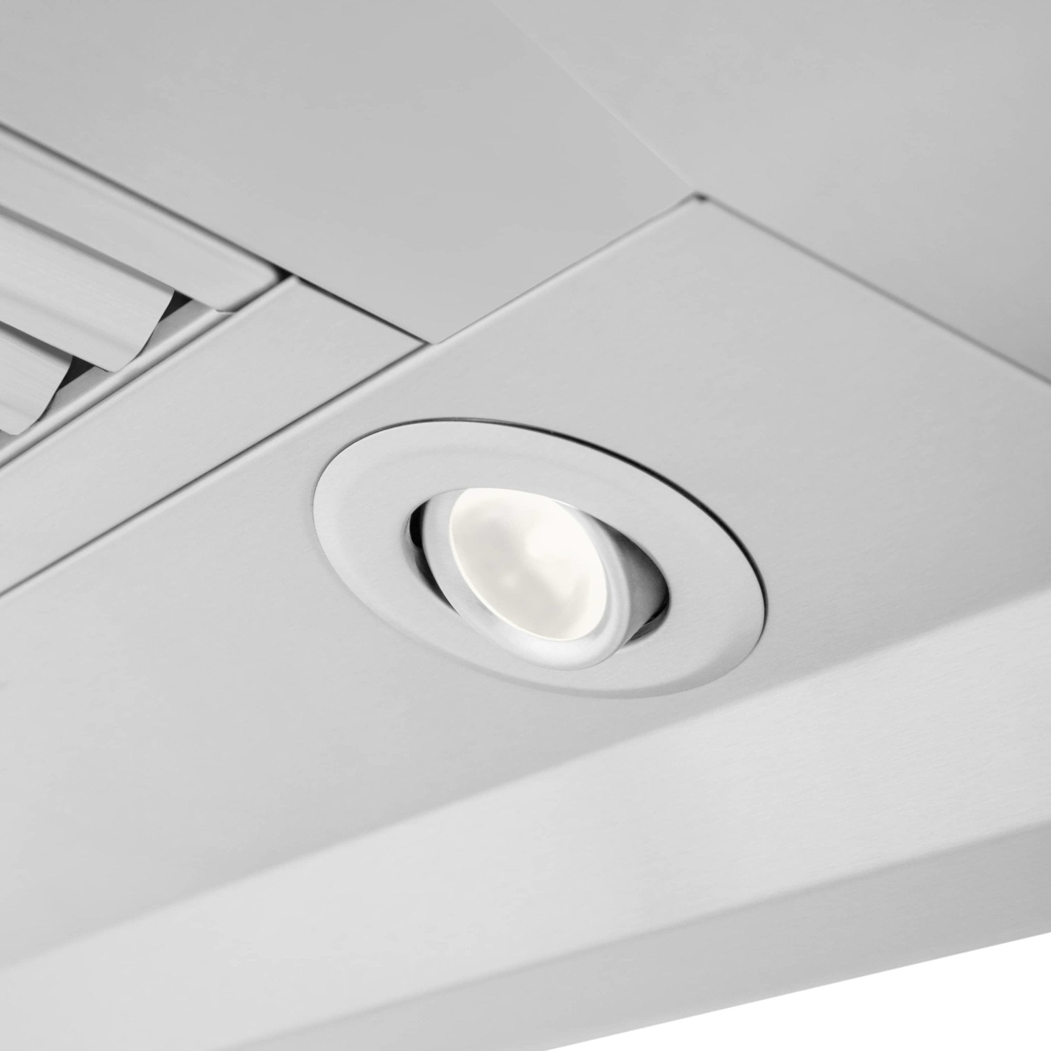 Range hood recessed light with round trim beneath vent baffles