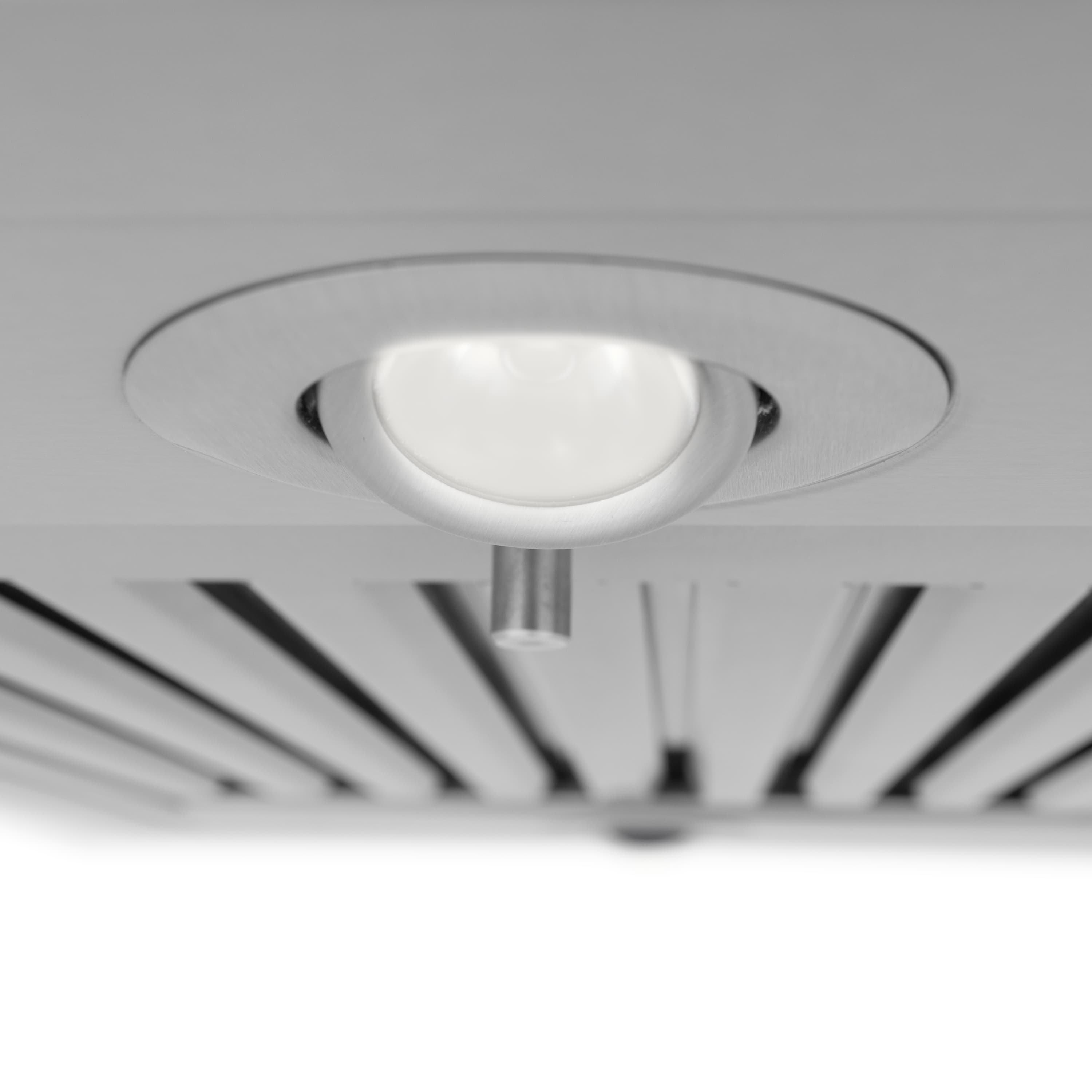Underlight lens in round trim on stainless steel range hood ceiling panel