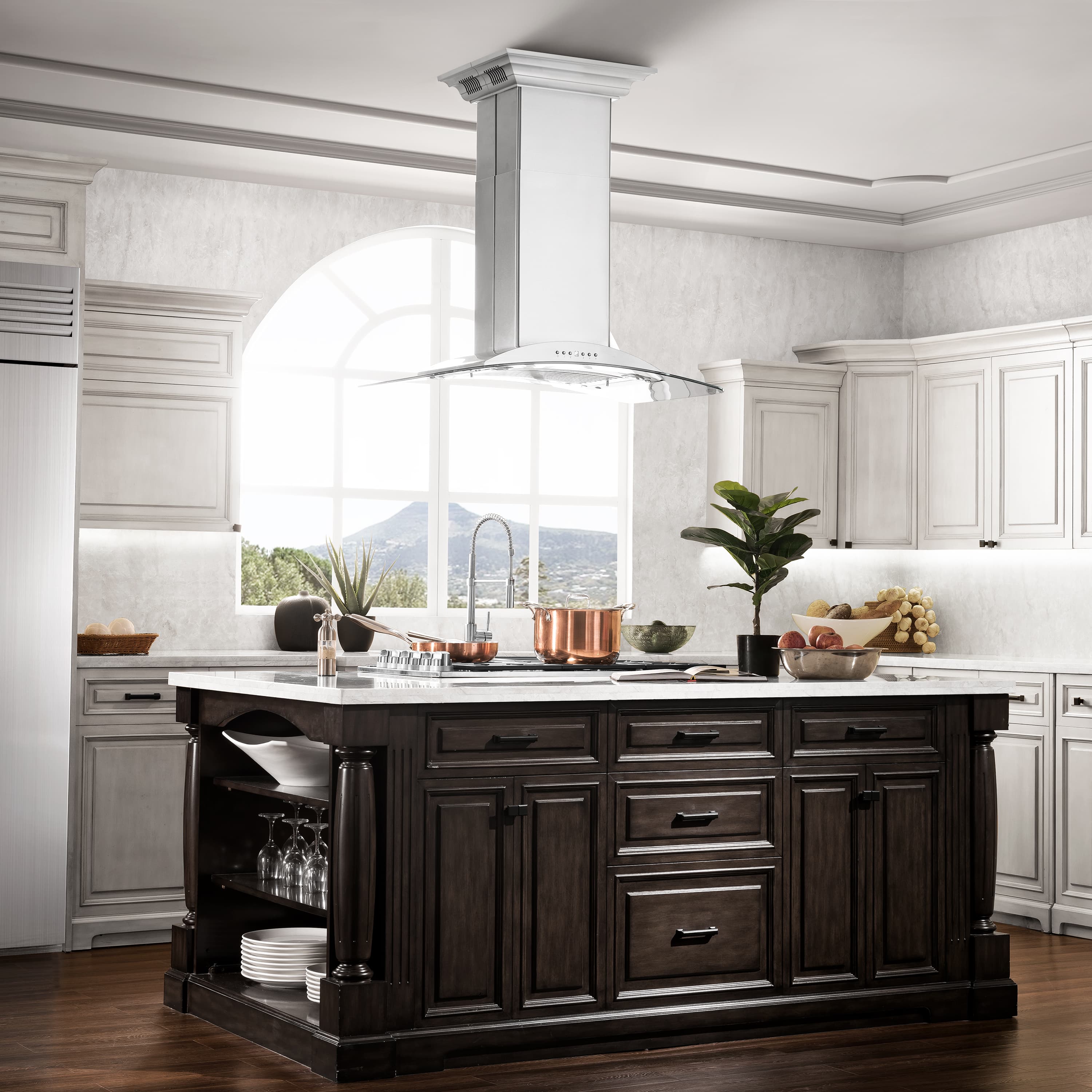 Stainless steel ducted island range hood centered over a kitchen cooktop