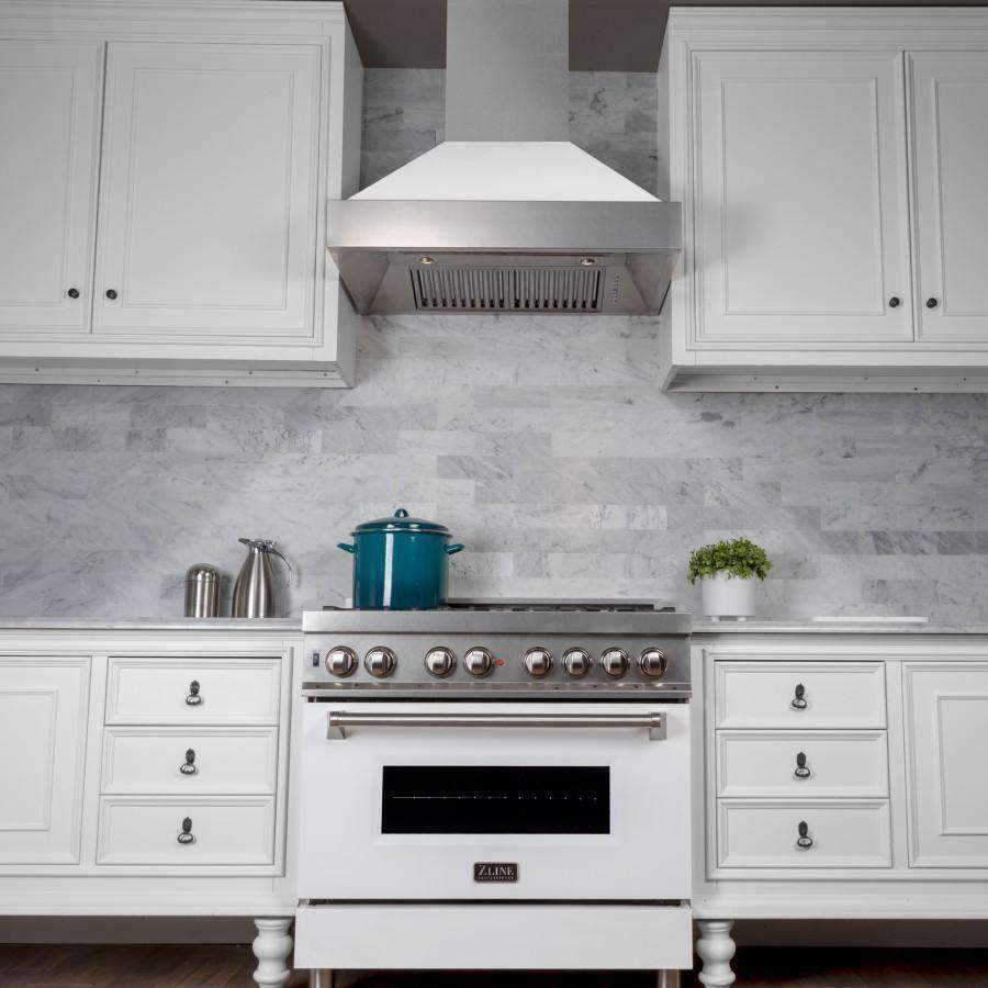 Wall-mounted range hood with white matte shell and stainless canopy, vent slots visible