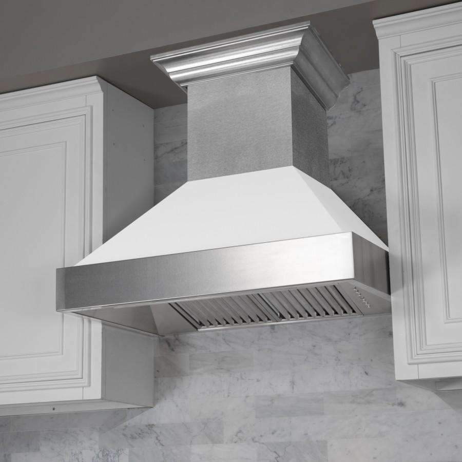 Close-up angled view of stainless wall range hood canopy and white matte chimney