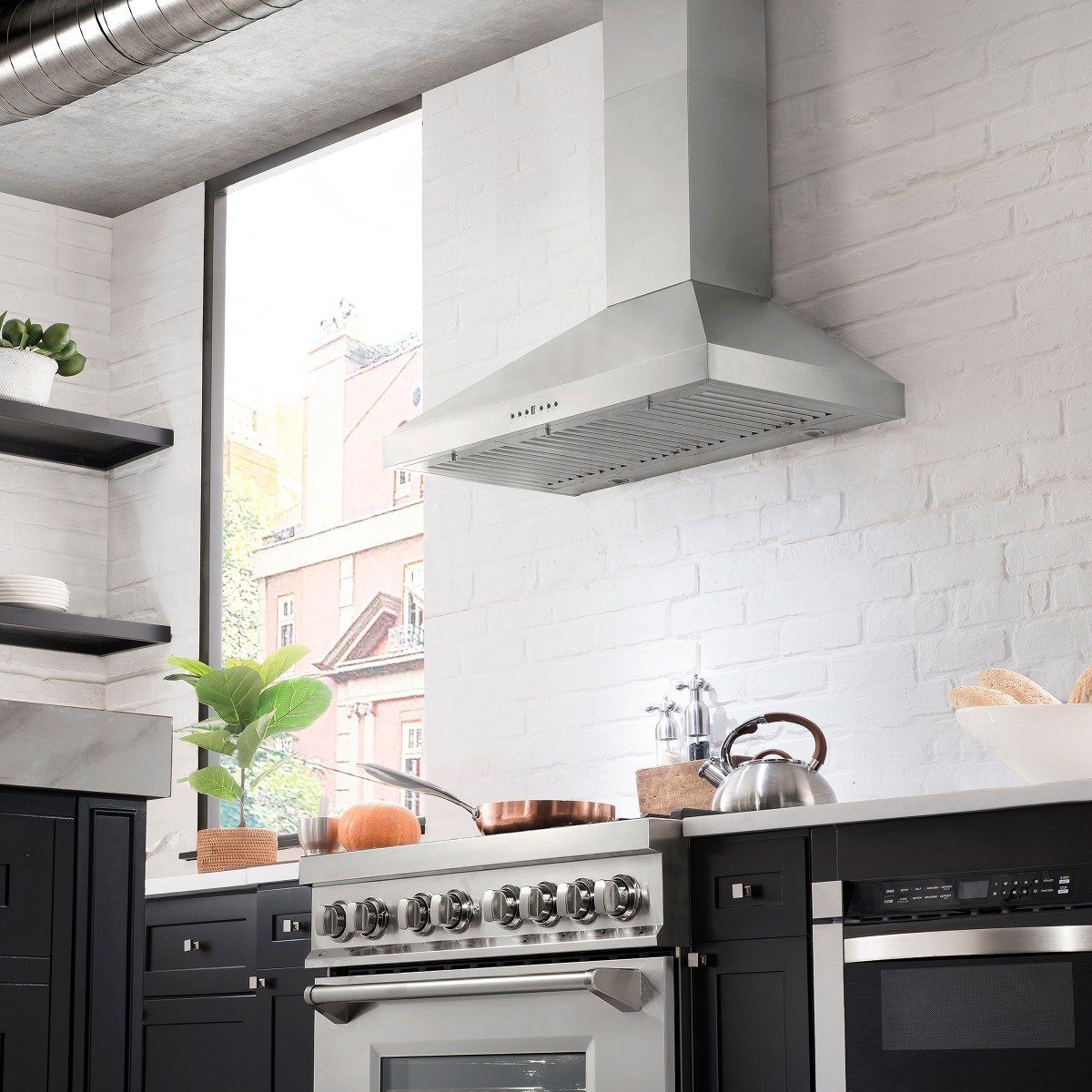 Stainless steel chimney range hood mounted above a gas cooktop