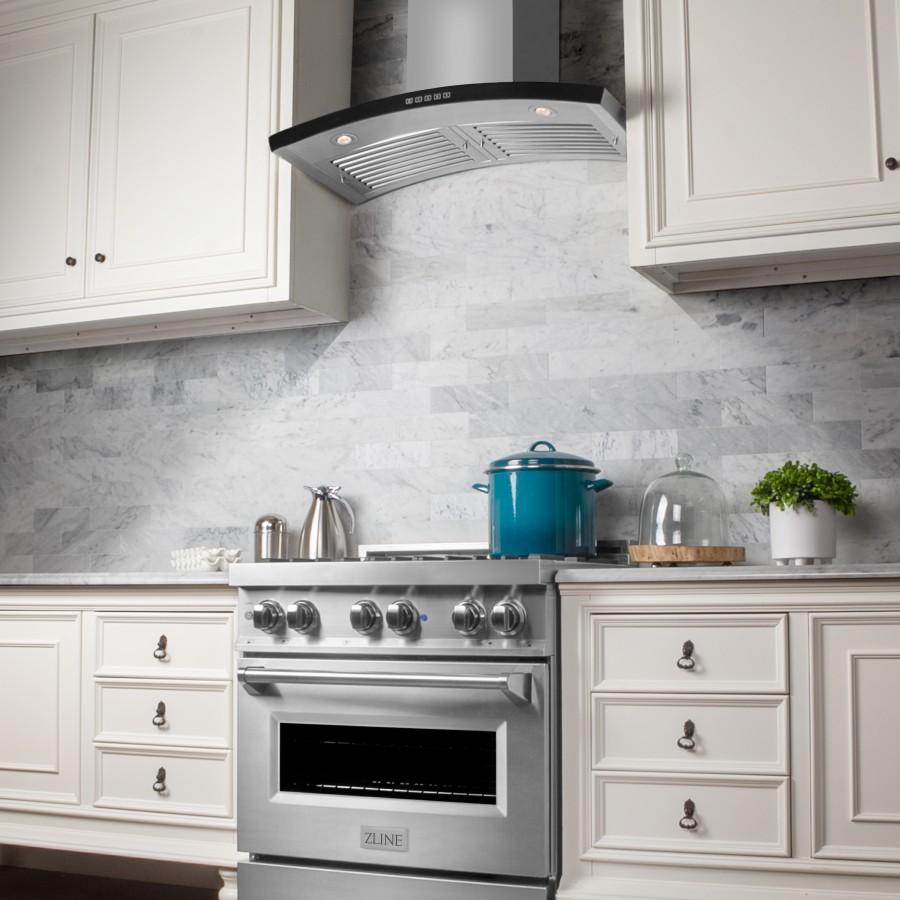 Stainless wall mount range hood with black trim over cooktop
