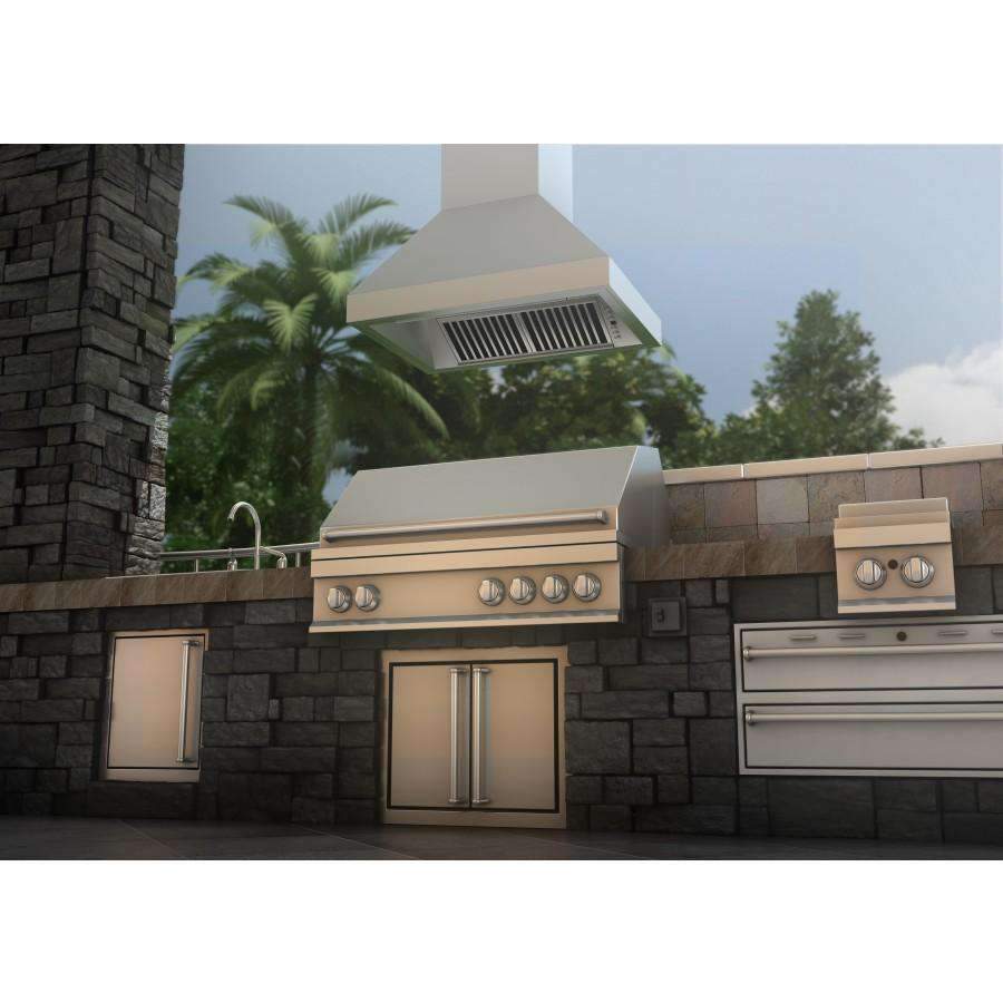 Stainless steel island range hood over outdoor kitchen appliances with stone wall