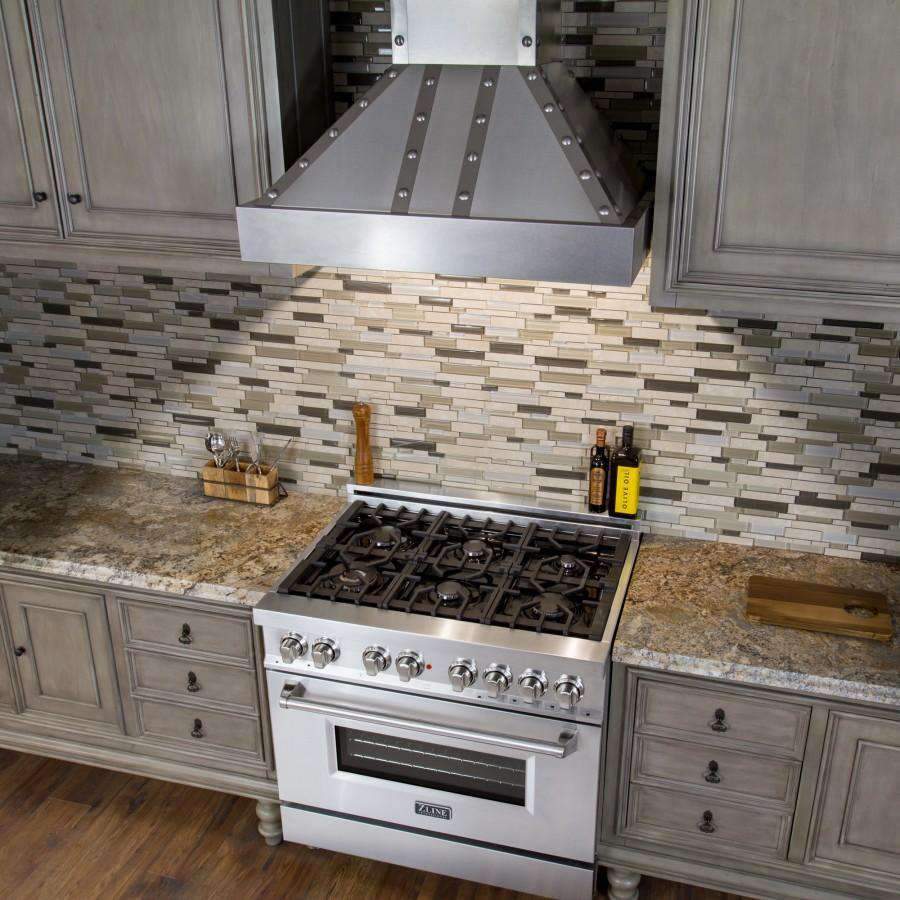 Stainless steel wall range hood canopy with baffle filters over gas cooktop