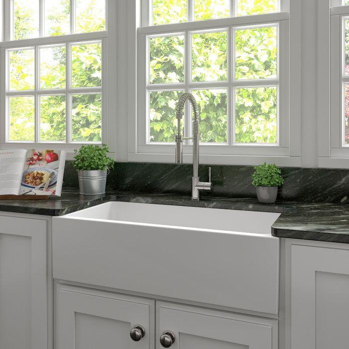 White farmhouse apron-front kitchen sink with single basin and faucet