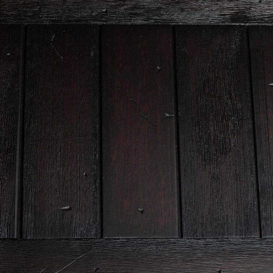Close-up of rustic dark wood grain panels for the range hood chimney