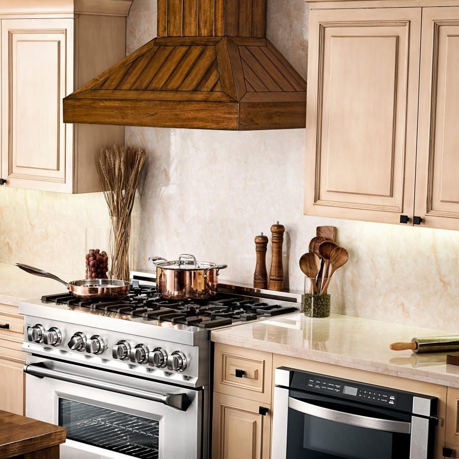 Rustic wooden wall range hood installed over a stainless gas range in a kitchen