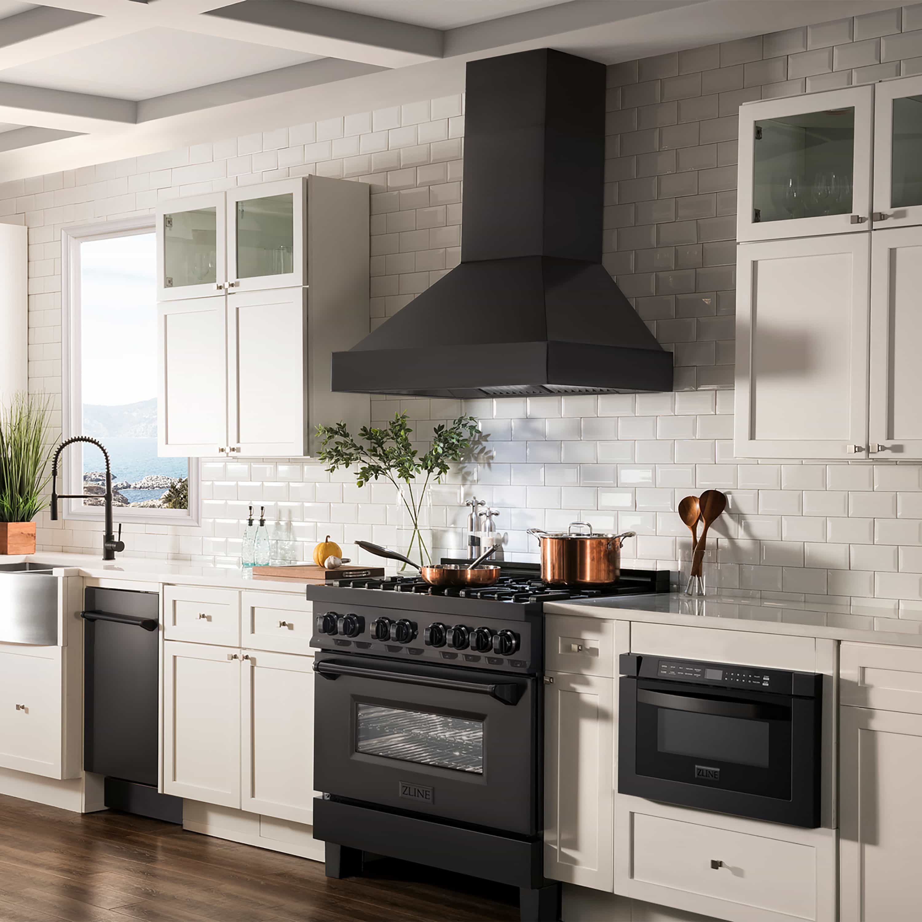 Black gas range with oven doors and range hood centered above burners