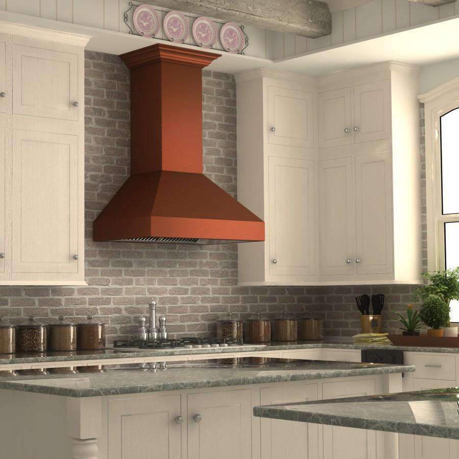 Copper-toned chimney wall range hood above cooktop with stainless vent grille