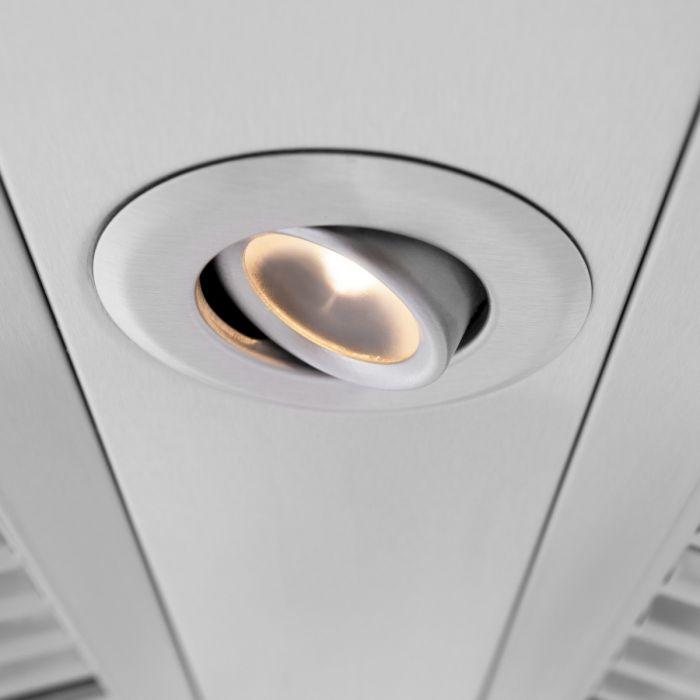 Round vent opening with warm light on the front panel of a wall range hood