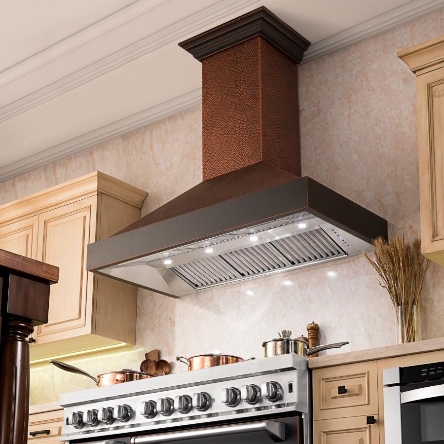 Installed copper wall range hood with dark chimney, lit vent grille, and control buttons