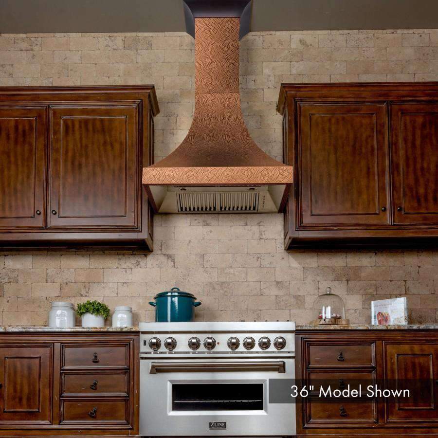 Hammered copper wall range hood with chimney duct and stainless vent panel